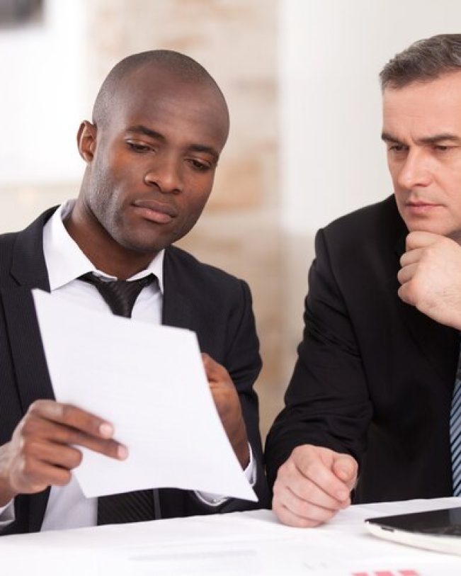 discutindo-um-projeto-dois-empresarios-confiantes-em-trajes-formais-discutindo-algo-enquanto-um-deles-aponta-um-papel_425904-29571